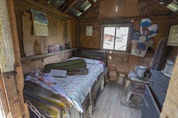 Clinton, Tennessee - The Museum of Appalachia, a collection of pioneer buildings and artifacts. Tom Cassidy's tiny cabin has a bed, fiddle, stove, and little else