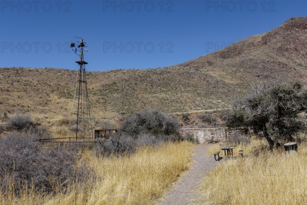 Picnic table and old abandoned windmill along the Bar Canyon Trail in Organ Mountains - Desert Peaks National Monument in New Mexico, USA
