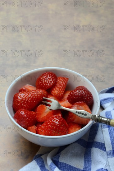 Sliced strawberries in hull with fork, Fragaria
