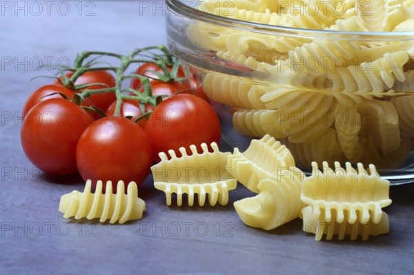 Italian pasta in glass bowl and cooking spoon, Radiatori variety