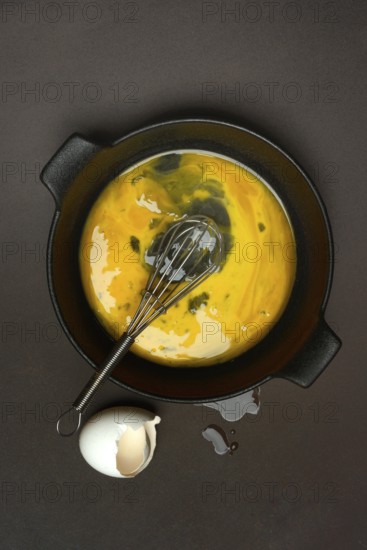 Cracked egg in a pan, hen's egg and eggshells