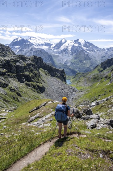 Mountaineer on hiking trail in mountain landscape, descent at Col du Louvie, view of the summit of the Grand Combine, Valais Alps, Val de Bagnes, Valais, Switzerland