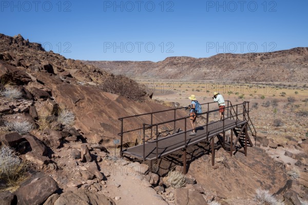Tourists on a platform at the rock engravings of Twyfelfontein, Twyfelfontein, Kunene, Namibia
