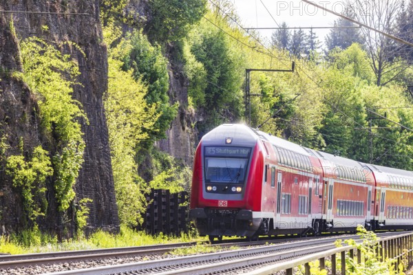 Regional express RE5 en route on the winding railway line of the Geislinger Steige. Landscape along the railway line in spring. Amstetten, Baden-Württemberg, Germany