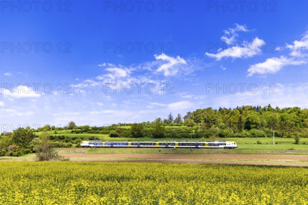 Regional train travelling on the Swabian Alb. Landscape on the railway line in spring. Lonsee, Baden-Württemberg, Germany