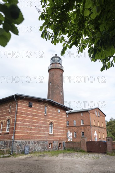 Lighthouse Darßer Ort, brick lighthouse next to a historic building, surrounded by trees under a cloudy sky, Prerow, Mecklenburg-Vorpommern, Germany