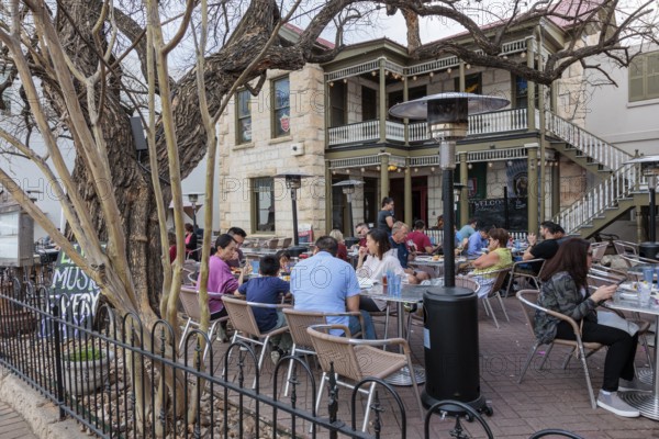 Tourists eating outside on the patio of the Silver Creek Beer Garden in Fredericksburg, Texas, USA