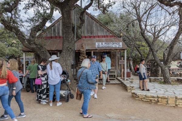Tourists mingle outside the US post office in Luckenbach, Texas, USA