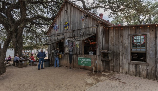 Tourists buying beer at an open-air bar in Luckenbach, Texas, USA
