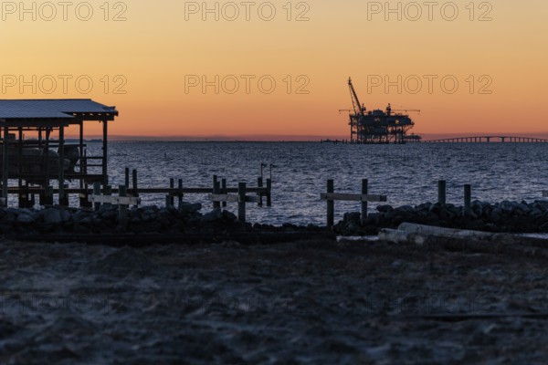 Fossil fuel drilling rig on the Gulf of Mexico horizon at Fort Morgan, Alabama, USA