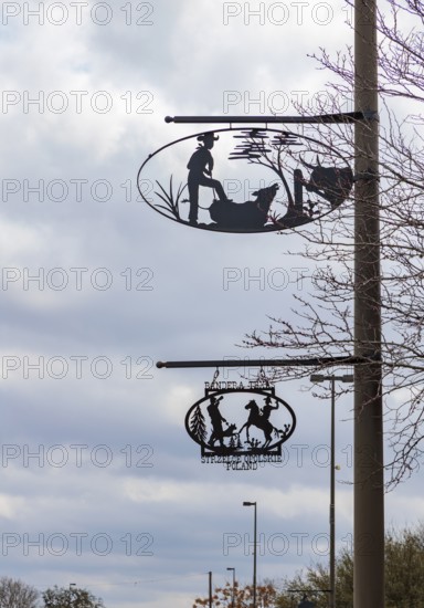 Artistic metal signs showing cowboy life on poles in Bandera, Texas, USA