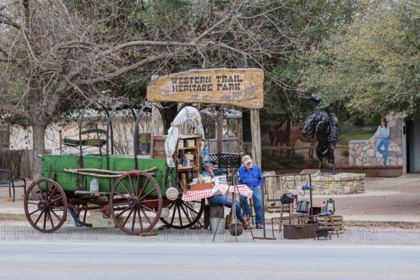 Senior men demonstrating a covered wagon camp site outside the Western Trail Heritage Park in Bandera, Texas, USA