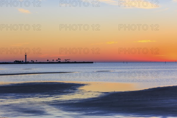 Sunrise silhouette of Broadwater Beach Marina Light at Biloxi, Mississippi, USA