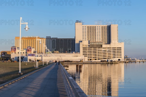 Concrete walkway along the Biloxi waterfront next to Margaritaville and Golden Nugget casinos in Biloxi, Mississippi during the golden hour