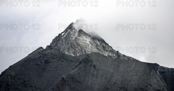 Rocky mountain peak shrouded in clouds, Valais Alps, Valais, Switzerland