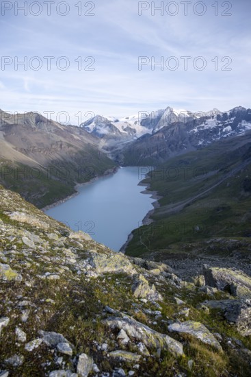 View at the summit of Mont de la Blana, view of a blue mountain lake, Lac des Dix reservoir, behind mountain peak Mont Blanc de Cheilon with glacier, Hérménence, Valais Alps, Valais, Switzerland