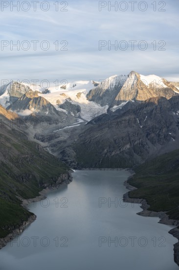 View at the summit of Mont de la Blana, in evening light, view of a blue mountain lake, reservoir Lac des Dix, behind mountain peak Mont Blanc de Cheilon with glacier, Hérménence, Valais Alps, Valais, Switzerland