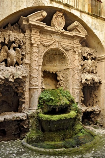 Ornamental fountain from the Renaissance, fountain with moss and artificial dripstone from the Mannerist period, courtyard of Palazzo Conti, historic centre, Poli, Monti Prenestini, metropolitan city of Rome, Lazio, Italy