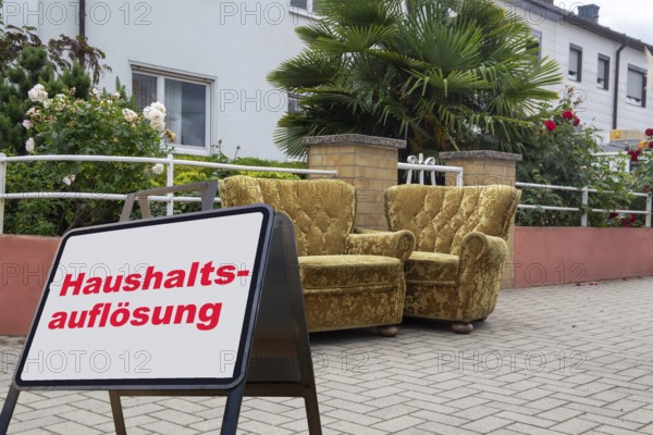(Photomontage) Sign with the inscription HAUSHALTSAUFLÖSUNG in front of bulky waste at a residential building