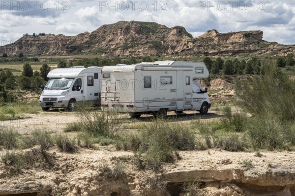 Camper van, colorful sandstone rock formations, desert, gravel road Ruta Jubierre, Desierto de los Monegros, Spain