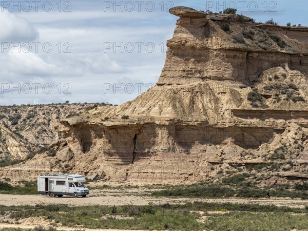 Camper van, desert, rock formation Tozal Colasico, colorful sandstone, gravel road Ruta Jubierre, Desierto de los Monegros, Spain