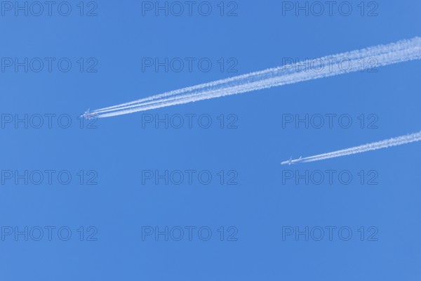 Two aeroplanes with vapour trails in the bright blue sky, Ternitz, Lower Austria, Austria