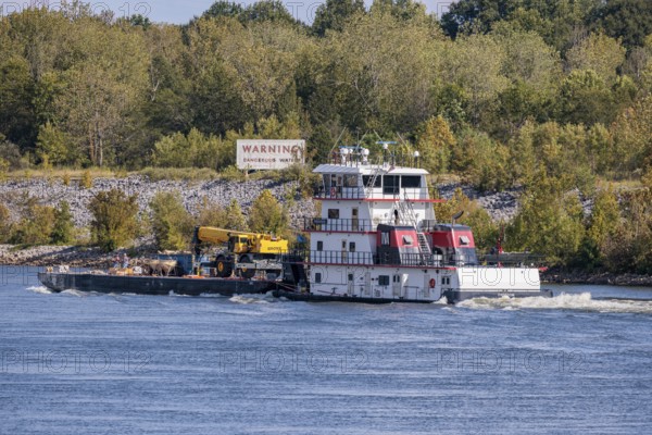 Tennessee Valley Authority tug boat Freedom pushing a barge with construction equipment upstream on the Tennessee River near Counce, Tennessee