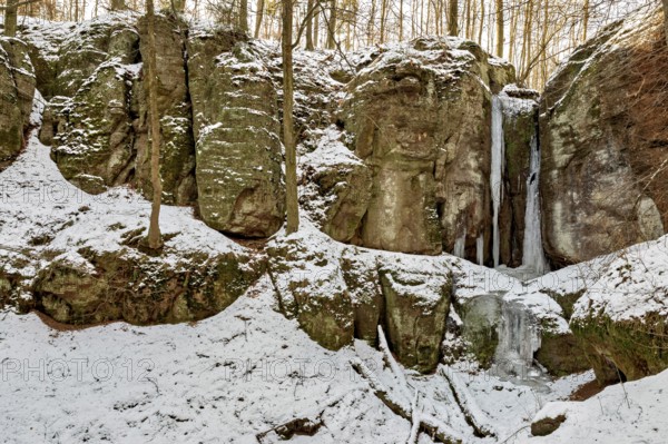 Snow-covered rocks with frozen waterfalls in a forest, The Dragon Gorge near Eisenach in Thuringia