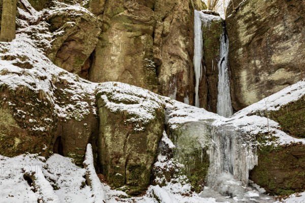 Frozen waterfalls on snow-covered rocks in a winter landscape, The Dragon Gorge near Eisenach in Thuringia