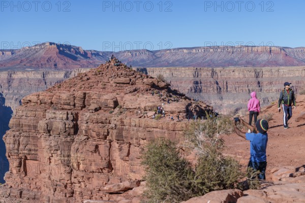 Visitors climb on rock formation rising above the canyon at Guano Point in Grand Canyon West near Peach Springs, Arizona