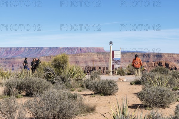 Native American security officer standing by sign with information about Eagle Point observation area at Grand Canyon West near Peach Springs, Arizona