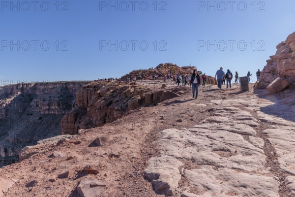 Tourists walk close to the edge of the canyon at Guano Point area of Grand Canyon West near Peach Springs, Arizona