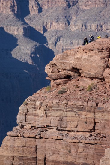 Visitors climb on rock formation rising above the canyon at Guano Point in Grand Canyon West near Peach Springs, Arizona