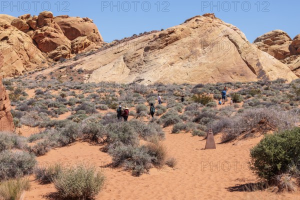 Hikers near the trailhead of the Fire Canyon Overlook Trail at Valley of Fire State Park near Overton, Nevada