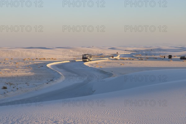 Motorhome being driven on cleared road through the white gypsum dunes at White Sands National Park in Alamogordo, New Mexico, USA