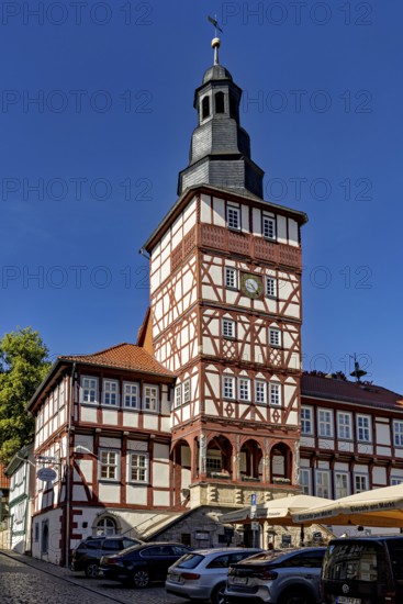 Half-timbered tower and historic buildings with parked cars under a blue sky, The town hall of Treffurt in Thuringia