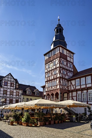 Historic half-timbered building with tower and sunshades on a market square under a clear blue sky, The town hall of Treffurt in Thuringia