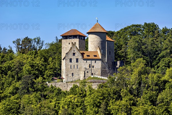 A medieval castle with two towers on a wooded hill under a blue sky, Normannstein Castle near Treffurt in Thuringia