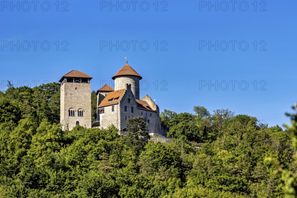 Old castle on a wooded hill in sunny weather and clear skies, Normannstein Castle near Treffurt in Thuringia