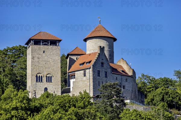 A medieval castle with two towers against a clear blue sky and surrounded by green trees, Normannstein Castle near Treffurt in Thuringia