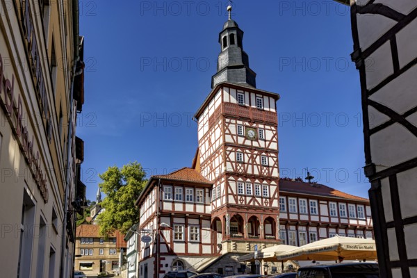 Half-timbered tower and surrounding buildings, seen through a narrow alley under a blue sky, The town hall of Treffurt in Thuringia