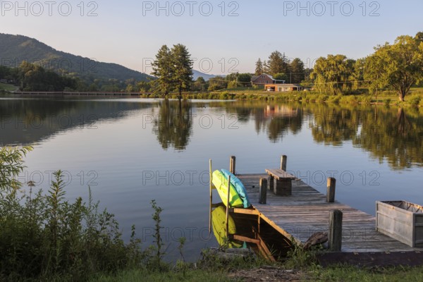 Private pier with a bench, kayak and paddleboard on the lake at Lake Junaluska, North Carolina