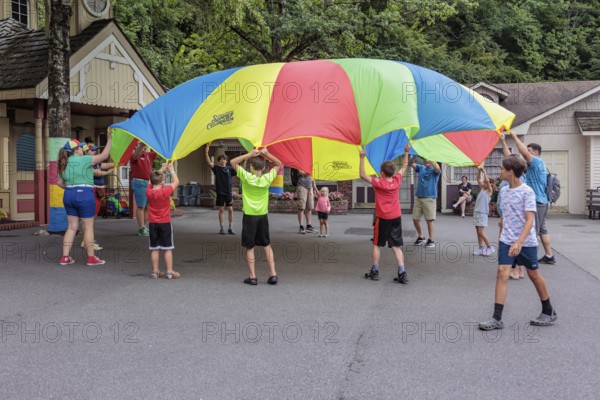 Children play with a parachute at the Dollywood amusement park in Pigeon Forge, TN