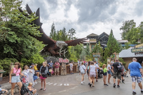 Park guests walk past a large steel sculpture of an eagle near the Wild Eagle wing roller coaster ride at the Dollywood amusement park in Pigeon Forge, TN
