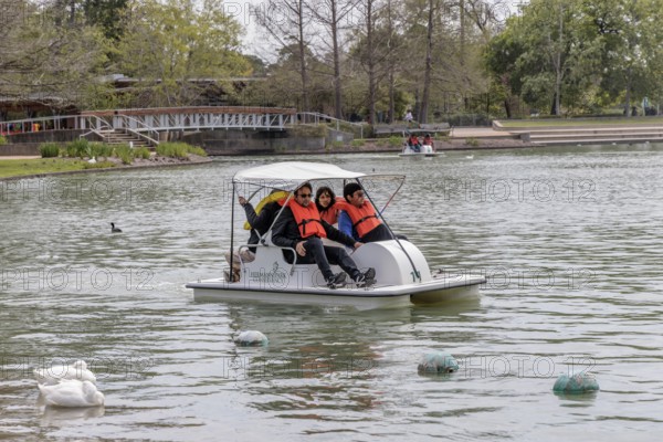 Young family piloting a pedal boat on Lake McGovern at Hermann Park in downtown Houston, Texas