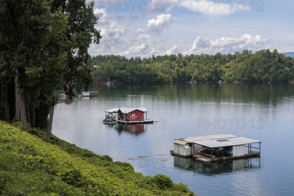 View of a house boats on Fontana Lake as seen from the open air car of the Great Smoky Mountains Railroad on its excursion from Bryson City, North Carolina