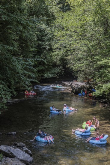 Visitors tubing down Deep Creek in the Smoky Mountains near Bryson City, North Carolina, USA