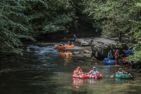 Visitors tubing down Deep Creek in the Smoky Mountains near Bryson City, North Carolina, USA