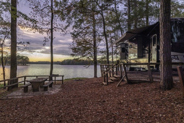 Motorhome parked on the shores of Archusa Creek Lake at sunset in Archusa Creek Water Park near Quitman, Mississippi