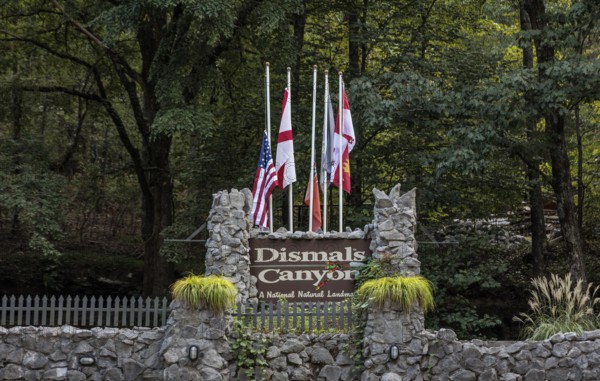 Sign with flags along the entrance to Dismals Canyon near Phil Campbell, Alabama, USA